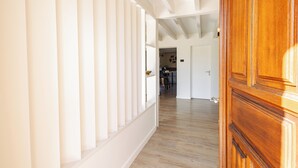 A hallway with wooden flooring, white walls, and a wooden door. - Villa Solanne - Garden, pool & comfort / 10 travellers (Narrosse)