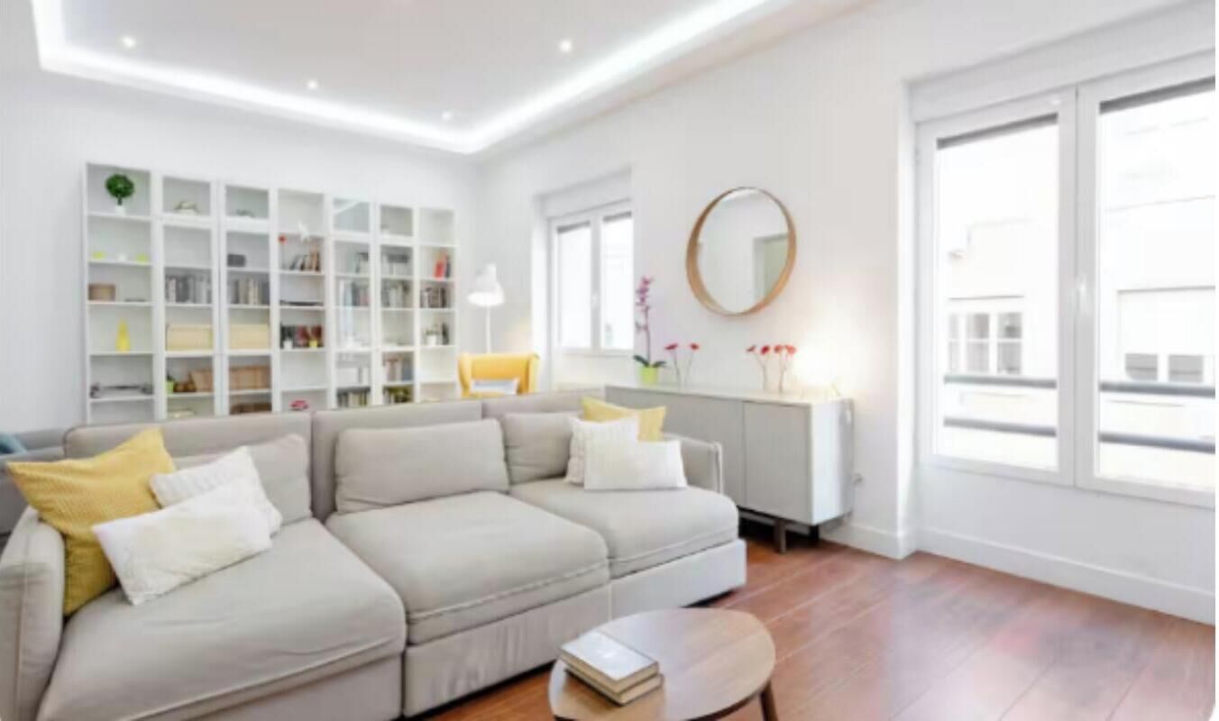Una sala de estar moderna con un sofá seccional, una mesa de centro y una estantería.