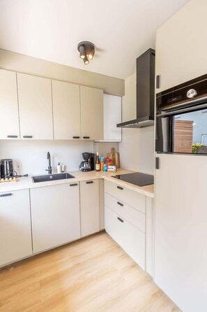Een koelkast, een oven, een kookplaat, een vaatwasser