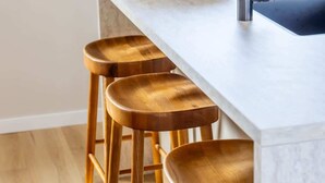 A kitchen with a white countertop and wooden stools. - Coastal apartment w/ sauna & balcony (Cadzand)