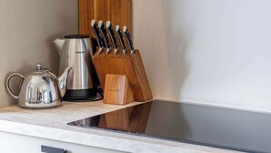 A kitchen with a stainless steel kettle, a coffee maker, and a knife block on the counter. - Coastal apartment w/ sauna & balcony (Cadzand)