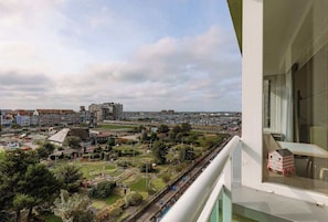 Een balkon met uitzicht op een stadsgezicht, inclusief gebouwen en een park.