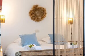 Ein Schlafzimmer mit einem Bett, Kissen, Wanddekoration und einer Lampe.