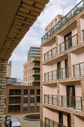 Un edificio de varios pisos con fachada de ladrillo, ventanas grandes y balcones.
