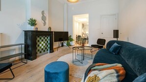Ein Wohnzimmer mit einer Couch, einem Couchtisch, einem Fernseher und einem Kamin.