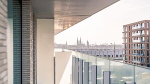 A modern building with a glass balcony overlooking a cityscape. - Beachside apartment w/ pool & gym access (Oostende)
