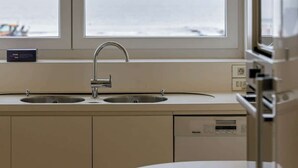 A modern kitchen with a large window, a sink, and a microwave. - 4-bedroom escape w/ backyard & beach access (Knokke-Heist)