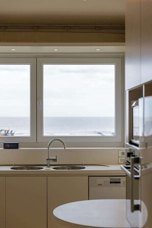 A modern kitchen with a large window, a sink, and a microwave. - 4-bedroom escape w/ backyard & beach access (Knokke-Heist)
