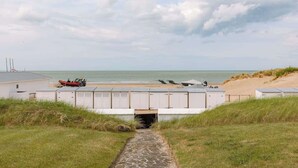 A coastal pathway leading to beach huts with a view of the sea. - 4-bedroom escape w/ backyard & beach access (Knokke-Heist)