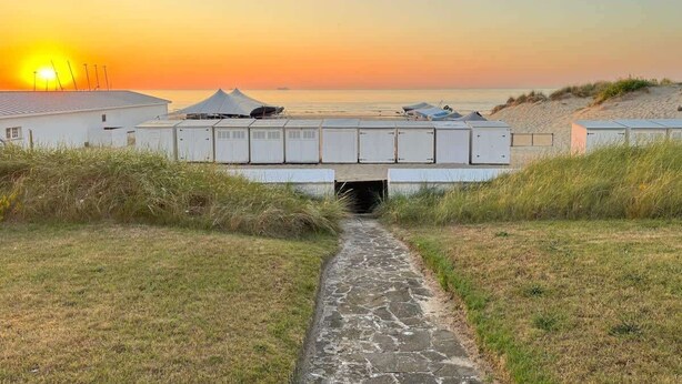 A pathway leading to a building with a view of the sunset over the water. - 4-bedroom escape w/ backyard & beach access (Knokke-Heist)