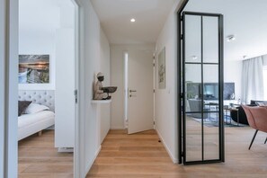 A modern living room with a sofa, a coffee table, and a dining area with a table and chairs. - Bright 2BR apt near coastal tram w/ terrace (Knokke-Heist)