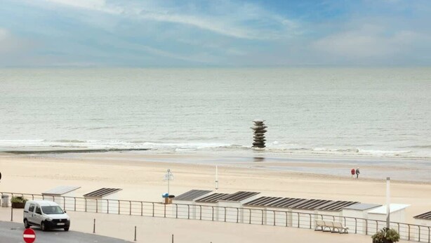 A beach view with a white van parked by the roadside, a no entry sign, and a row of beach chairs. - Charming 2BR apartment w/ kitchen & workspace (Oostende)