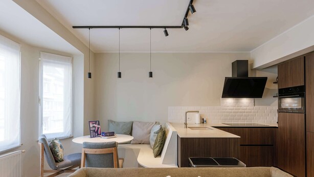 A modern kitchen with a dining area, a built-in oven, and a flat-screen TV. - Coastal retreat near Belgian coast (Knokke-Heist)