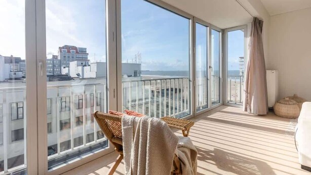 En balkon med udsigt til bygninger og havet.