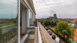Een balkon met uitzicht op een straat en een kerk.