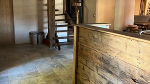 A wooden reception desk, a staircase, and tiled flooring. - Holiday Home 'Gite Les 4 Saisons' with Mountain View, Private Terrace and Wi-Fi (Val de Chaise)