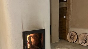 A room with a fireplace, a wooden bench, and a tiled floor. - Holiday Home 'Gite Les 4 Saisons' with Mountain View, Private Terrace and Wi-Fi (Val de Chaise)