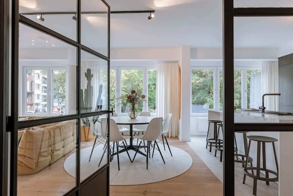 Un interior moderno con comedor, cocina y zona de estar.