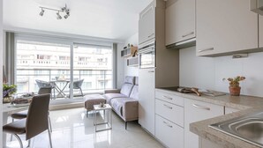 Una cocina moderna con comedor, ventanas amplias y un sofá.