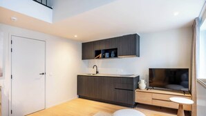 A modern living space with a kitchen, a TV, and a seating area. - Duplex studio near Ghent's centre (Gent)
