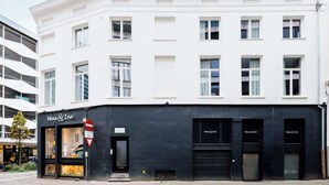 Ein zweistöckiges Gebäude mit weißer Fassade und dunklerem Unterteil.
