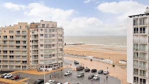 Ein Küstenhotel mit mehreren Etagen, einem Parkplatz und Blick auf den Strand.
