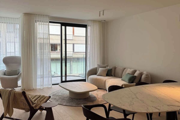 Modern living room with a curved sofa and large windows letting in natural light