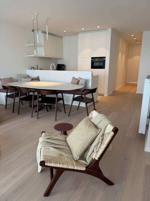 Un espacio habitable moderno con comedor, sofá y cocina.