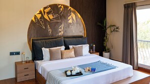 A modern bedroom with a large bed, a ceiling fan, a nightstand, a potted plant, and a view of the outdoors. - ELIVAAS Casa llios Stuning Getaway Villa (Udaipur)