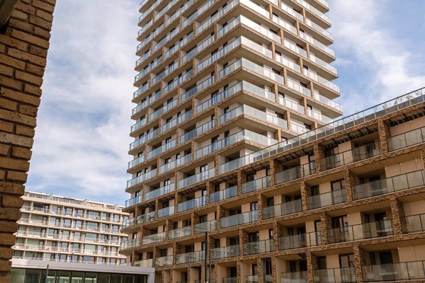 Modern apartment building with spacious balconies and a central courtyard.