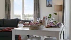 En matplats med ett bord dukat för två personer, en soffa och utsikt över omgivningarna.