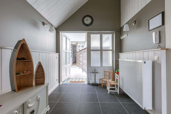 Entryway with vaulted ceiling and natural light from frosted glass doors.