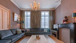 Ein Wohnzimmer mit einer Couch, einem Couchtisch, einem Kamin und einer Chandelier.