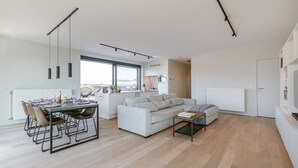 A modern living space with a dining area, sofa, and kitchen. - Bright 2BR apartment w/ balcony & private entrance (Gent)