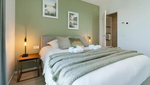 Una camera da letto con un letto, abat-jour e due quadri appesi al muro.