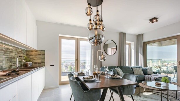Una cucina moderna con zona pranzo, ampie finestre e vista sulla città.
