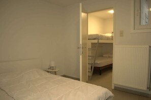A bedroom with a bunk bed, a small bedside table, and a radiator. - Coastal retreat near beach w/ kitchen (Oostende)