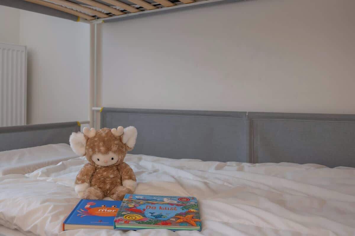 Ein Bett mit einem Kuscheltier und zwei Büchern.