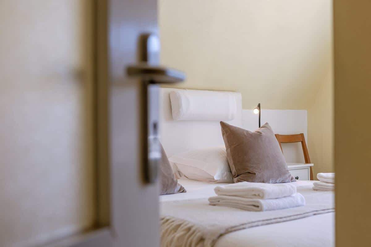 view into a cozy bedroom with neatly arranged towels and soft pillows