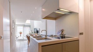 Een moderne keuken met een centraal eiland, ingebouwde apparatuur en een eetgedeelte met uitzicht.