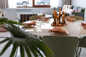 A dining table set with plates, glasses, and candles, with a view of a car outside. - Family retreat near beach w/ full kitchen (Knokke-Heist)