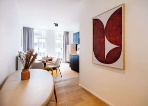 A modern interior with a dining area, a large abstract painting, and a view to the outside. - Bright studio retreat w/ workspace (Gent)