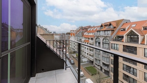 A residential building with multiple balconies, a clear sky, and a view of neighboring houses. - Beachfront Apt w/Terrace, City View & Fast WiFi (Knokke-Heist)