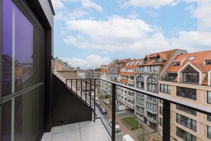 A residential building with multiple balconies, a clear sky, and a view of neighboring houses. - Beachfront Apt w/Terrace, City View & Fast WiFi (Knokke-Heist)