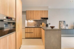 Eine moderne Küche mit Holzausstattung, einem eingebauten Ofen und einer Arbeitsfläche.