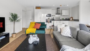 Uma sala de estar moderna com um sofá, uma mesa de centro e uma televisão.