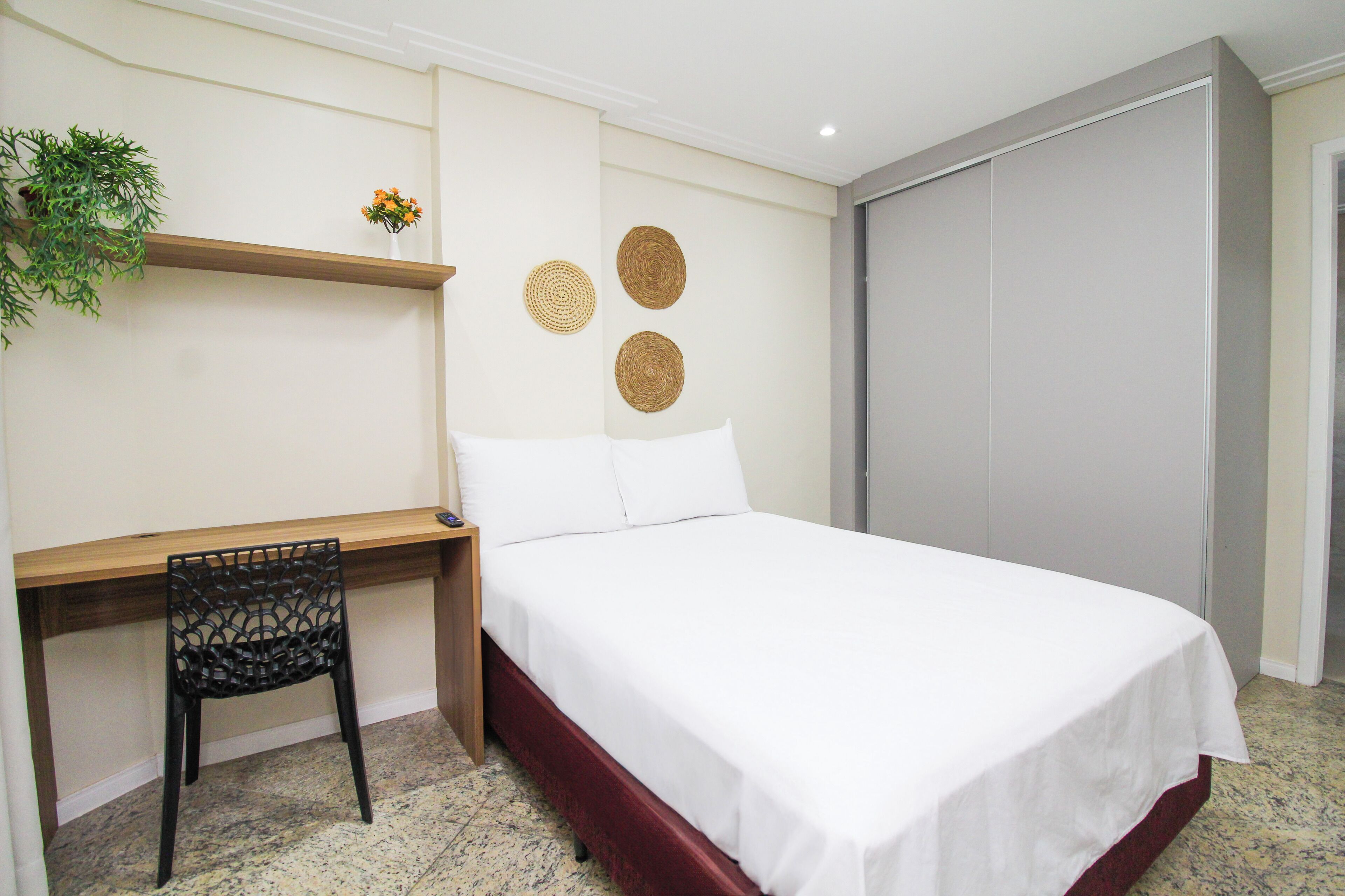 Un dormitorio con una cama, un escritorio y una silla.