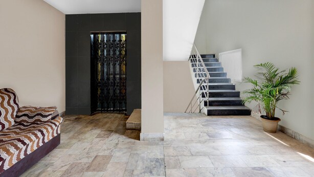 Un intérieur moderne avec un canapé, un escalier et une plante en pot.