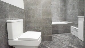Un baño moderno con inodoro, ducha y tocador.