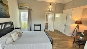 A bedroom with a bed, bedside table, lamp, and wardrobe. - Secure & Peaceful Residence – Beach 600m & Nearby Amenities (Flic-en-Flac)